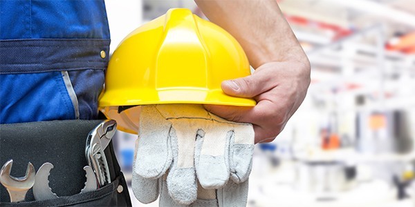Bauarbeiter hält Helm und Handschuhe